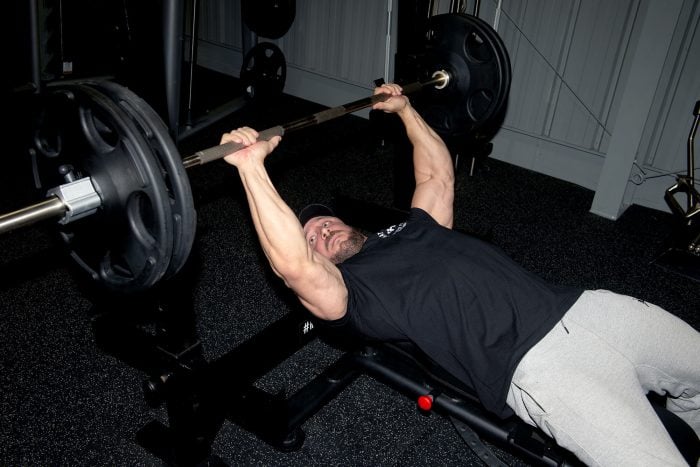 Weightlifter performing a bench press using Hampton Olympic Grip Plates.