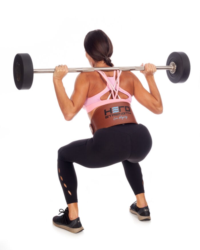 female athlete with straight barbell racked on her shoulders