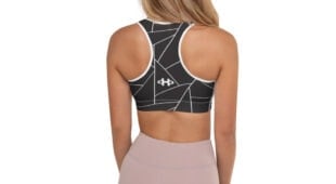 blonde woman, black and white racerback bra with geometric designs, facing back and muted mauve leggings