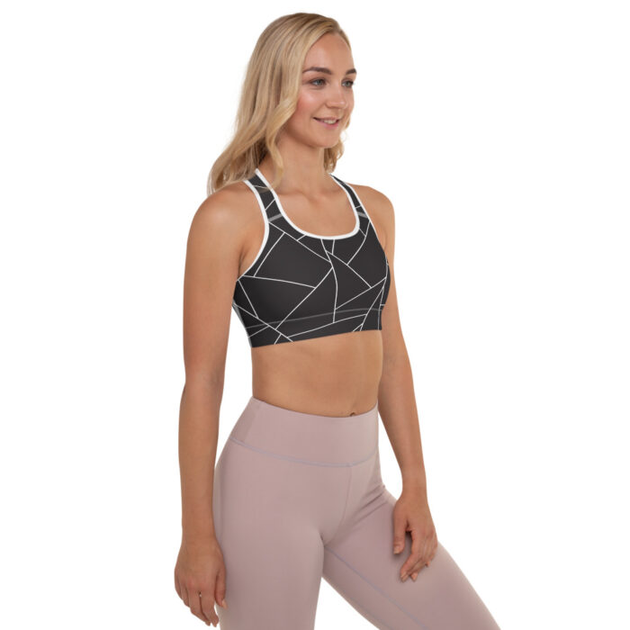 blonde woman, black and white racerback bra with geometric designs, side facing and muted mauve leggings