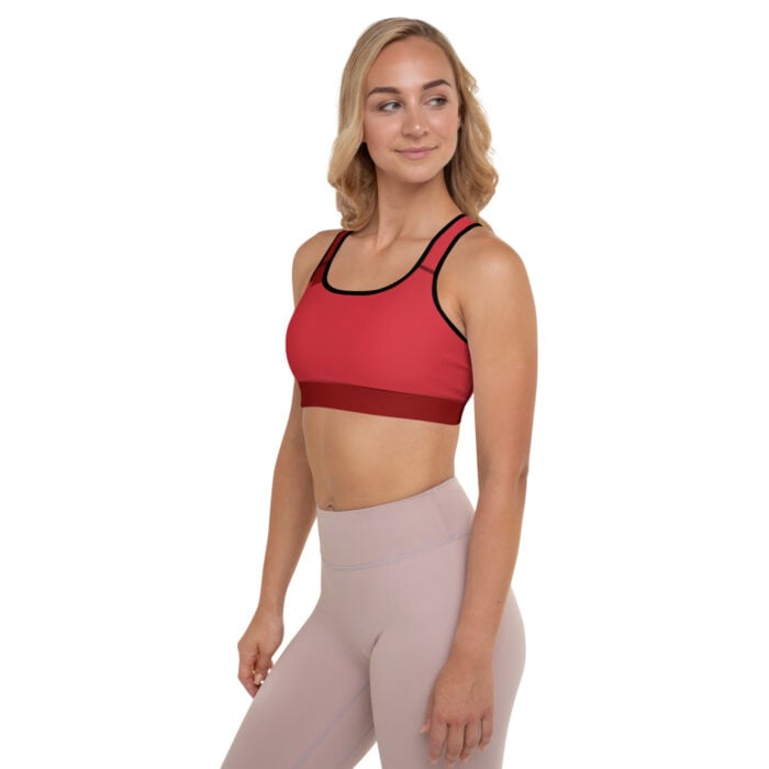 blonde woman facing front with red sports bra and muted mauve leggings
