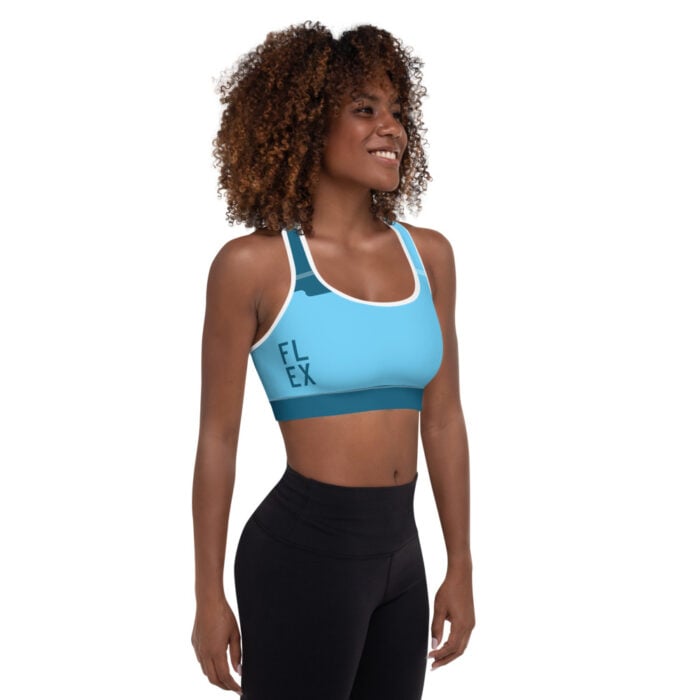 African American woman to the side facing camera with short natural hair blue racerback sports bra and black leggings