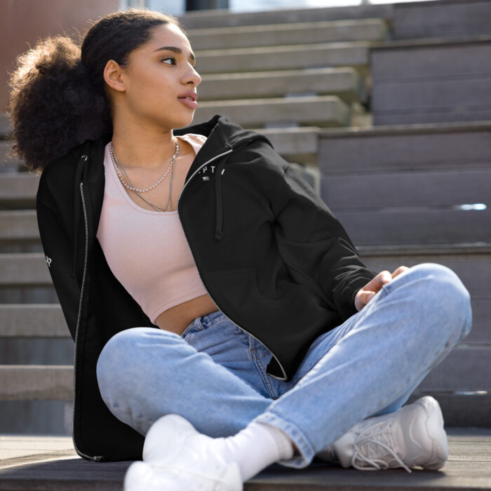 female sitting outside modeling a black hampton zip up hoodie with logo on chest